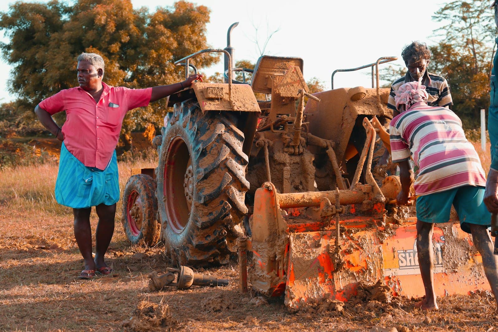 Productor y técnico junto a un tractor en un campo argentino